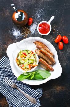 grilled sausages with salad on white plate, stock photo