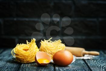 raw egg noodles and yolk on a table