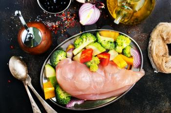 raw chicken fillet with fresh vegetables on plate