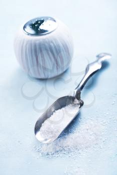 sea salt in metal spoon and on a table