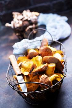raw mushrooms in basket and on a table