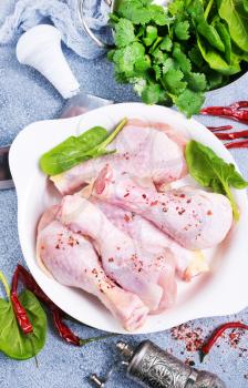 raw chicken legs with fresh spinach and spices