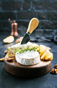 cheese with nuts and honey on wooden board