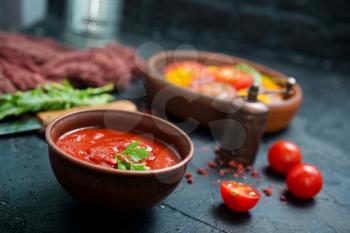 tomato sauce in bowl and fresh tomato on a table