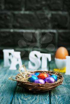 color easter eggs in nest and on a table