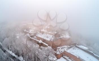 Winter view of the Chateau du Haut-Koenigsbourg in fog. A major tourist attraction in Alsace, France