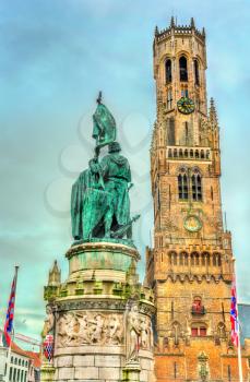 Statue of Jan Breydel and Pieter de Coninck and the Belfry of Bruges, a medieval bell tower in West Flanders Province of Belgium