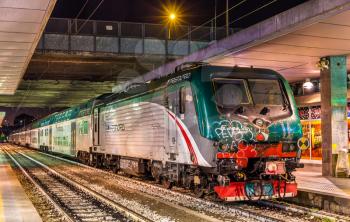 Milan, Italy - May 8, 2014: Class E.464 locomotive hauling a regional train at Milano Porta Garibaldi railway station. Trenord is a regional passenger company in Lombardy