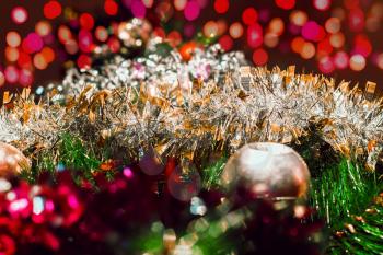 Christmas background with a bright ball and silver tinsel and multicolored lights