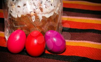 Painted Easter eggs and Easter cake on a plaited background