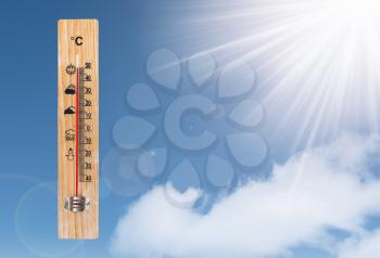 Thermometer with high temperature and the sun on a blue sky