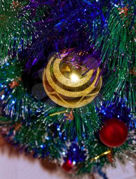 Artificial Christmas tree decorated with tinsel and a glass ball