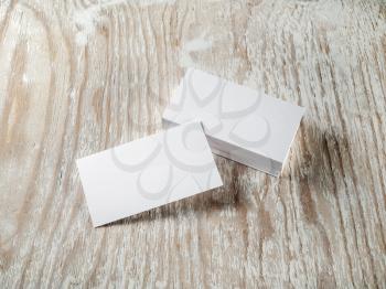 Photo. Blank business cards with soft shadows on light wooden background. Template for ID. For design presentations and portfolios.