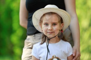 Child, a small little girl in yellow hat looking into the camera. Blurred background. Shallow depth of field. Focus on the model's face.