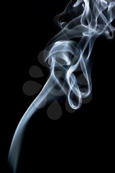 Abstract curls of smoke on a black background. Vertical shot.