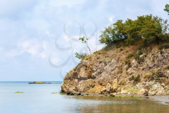 A rocky cliff on sea and sky background. Rock on the shore of the Black Sea. Scenic seascape.