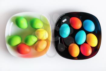 Two dishes with multi-colored bright Easter eggs. Top view.
