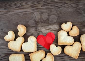 Heart shaped cookies and red heart on wooden background. Top view. Space for text on top.