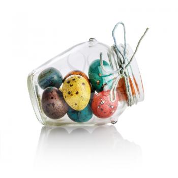 Bright colorful easter eggs in a glass jar. Easter still life. Isolated with clipping path on white background.