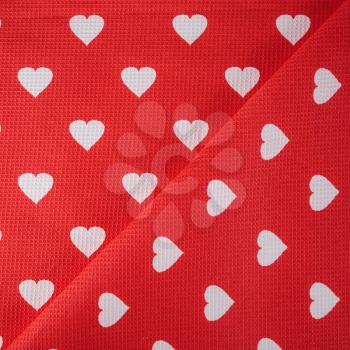 Texture of white hearts on a bright red fabric