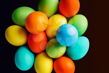 Bright colored Easter eggs on dark background. Isolated with clipping path. Top view.