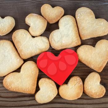 Heart shaped cookies and red heart on wooden background. Top view.