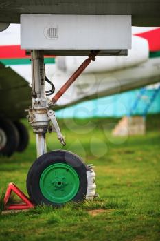 Front landing gear light aircraft on green grass. Shallow depth of field. Selective focus.