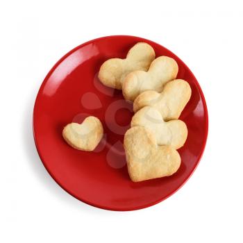 Cookies in the form of hearts in a red plate on a white background. Isolated with clipping path. Top view.