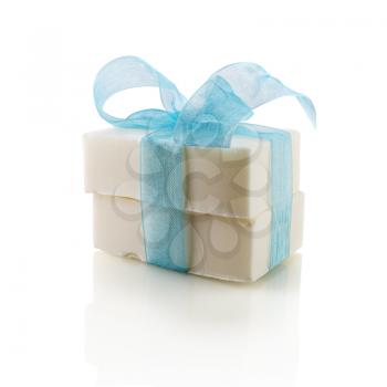Two pieces of soap, tied with a blue ribbon with a bow on a white background. Isolated with clipping path.