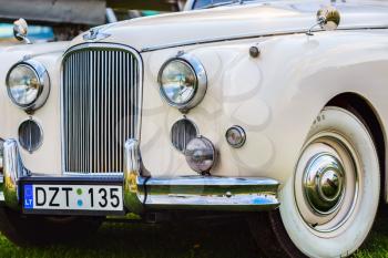 MINSK, BELARUS - MAY 07, 2016: Close-up of white Jaguar Mk VIII. This classic car was produced in the years 1956-1958. Front part of an vintage retro auto. Selective focus on the car's headlight.