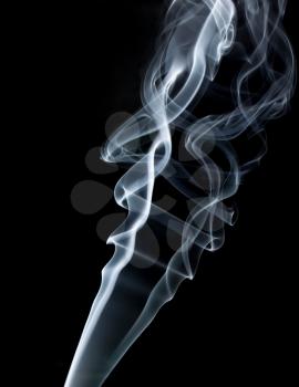 Photo of abstract smoke swirls on black background. Vertical shot.