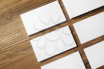 Photo of blank business cards on wooden table background. Blank paperwork template for placing your design.Top view.