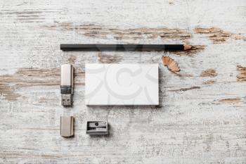Photo of blank stationery set. Bank business cards, pencil, usb flash drive and sharpener on vintage wooden table background. Template for branding identity for designers. Top view.
