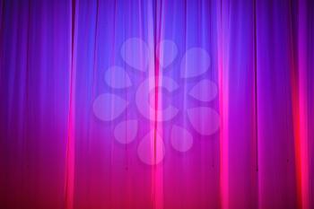 Bright pink and purple stage curtain with spotlight. Abstract background.