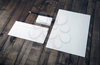 Photo of blank corporate stationery set on wood table background.