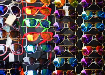 Many colorful sunglasses on the shop window.