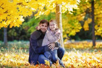 Dad with daughter in the park in the fall. Happy family. Sunny autumn day. Selective focus.