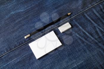 Blank business cards, pencil and eraser on denim background. Mockup for branding identity.