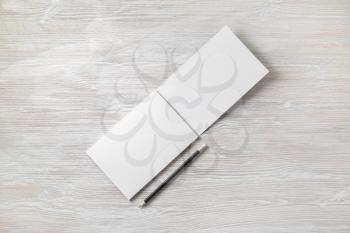 Photo of open sketchbook with blank pages and pencil on light wood table background. Responsive design template. Flat lay.