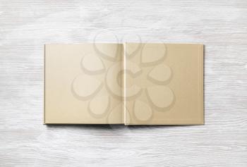 Open blank craft paper book on wooden background. Flat lay.