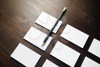 Blank business cards and pencil on wood table background. Template for branding identity.