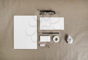 Photo of blank ID set. Stationery template on paper background. Branding mockup. Letterhead, business cards, envelope, pencil, glasses, eraser and scotch tape. Top view.