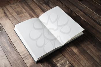 Blank open book, brochure or notebook on wooden table background. Responsive design mockup.