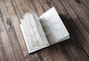 Blank open book on wooden table background. Mock up for placing your design.