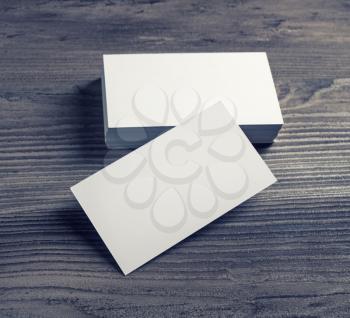 Blank white business cards on dark wooden background. Template for design presentations and portfolios.