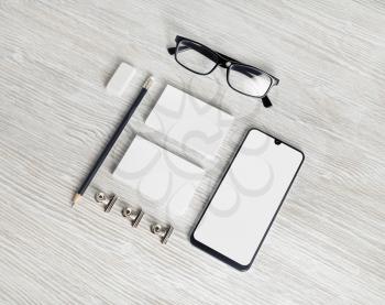 Photo of blank corporate identity. Stationery set. Branding mockup. Smartphone, business cards, pencil, eraser and glasses