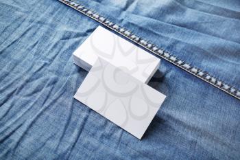 Photo of blank business cards on denim background. For design presentations and portfolios.