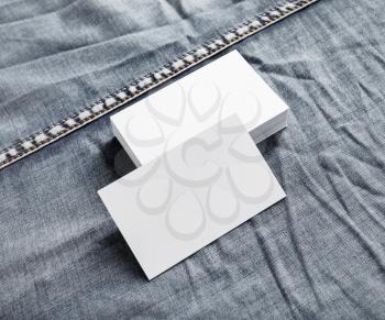 Blank name cards template. White paper business cards on denim background.