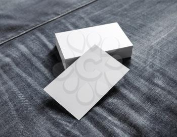 Blank name cards on gray denim background. Mockup of business cards. Selective focus.