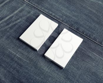 Photo of blank business cards on denim background.